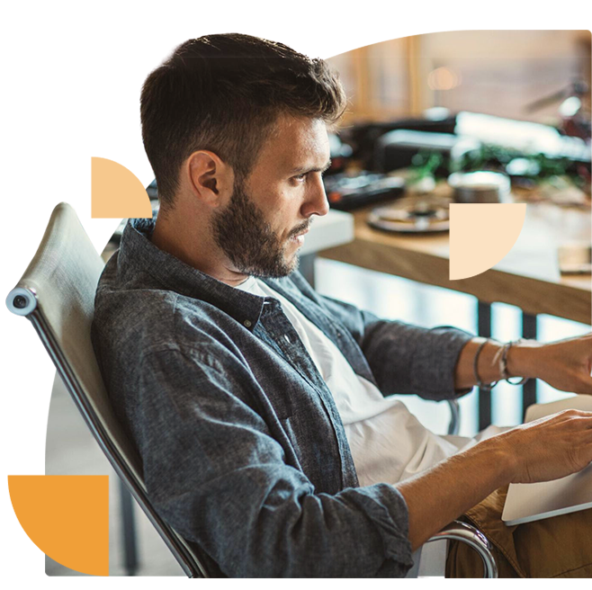 Focused young professional engaged in cybersecurity tasks on his computer in a casual office setting.