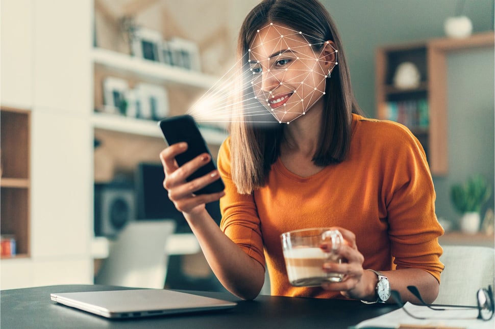 Voorbeeld van 2FA waarbij een vrouw gezichtsherkenning toepast op haar smartphone voor veilige toegang tot haar gegevens.