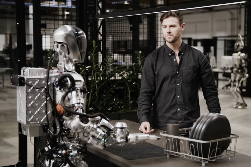 De interactie tussen mens en AI-robot in een moderne werkruimte.