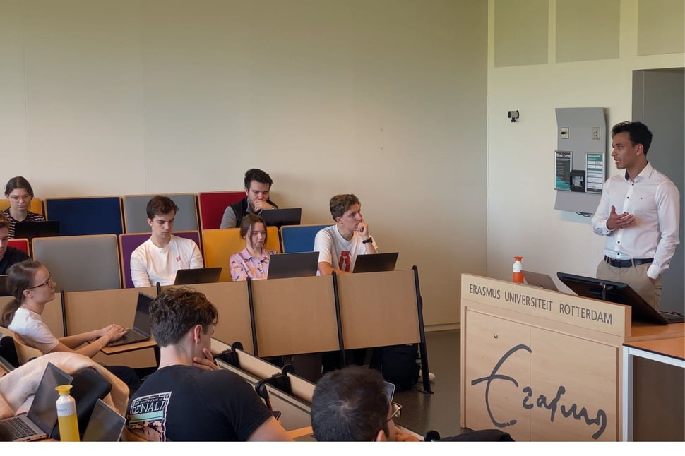 Studenten van de Erasmus Universiteit Rotterdam volgen een lezing over crisissimulatie, waarbij een expert hun vragen beantwoordt.