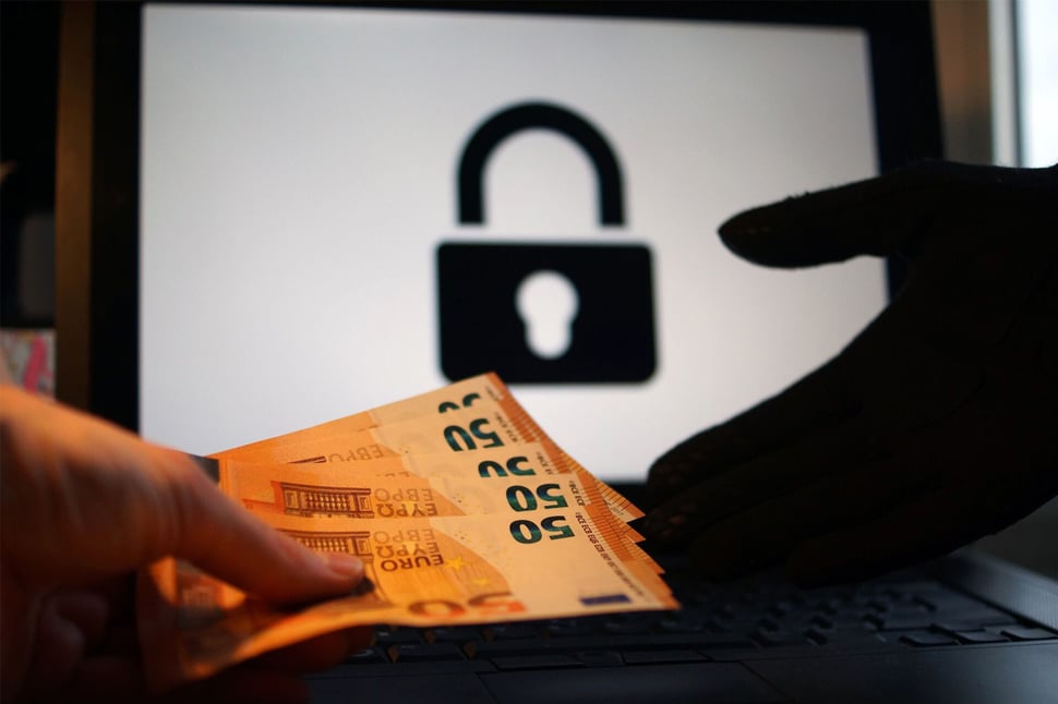 Ransomware aanvallen en losgeld: afbeelding toont bankbiljetten die worden overgedragen voor het ontgrendelen van versleutelde gegevens.