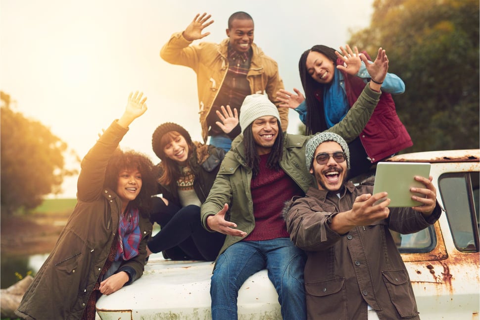 Vriendengroep poseert voor een selfie, een moment dat de risico's van social media blootstelt wanneer persoonlijke momenten worden gedeeld.