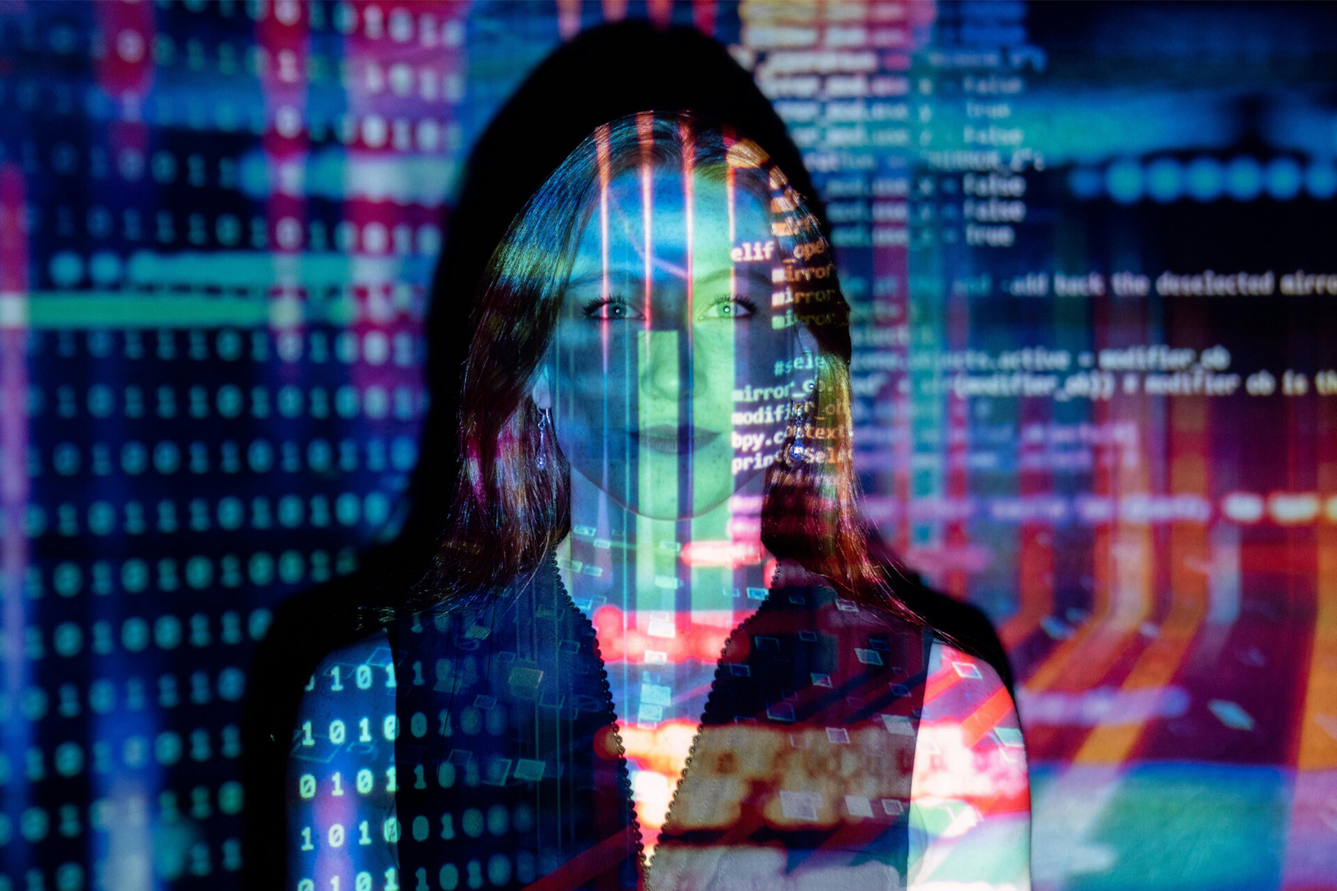 Woman looks straight ahead while lines of computer code are projected across her face.